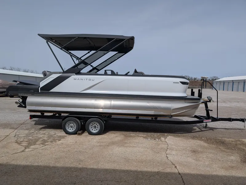 Slide: The Image of 2025 Manitou Cruise pontoon boat on trailer, featuring sleek design and canopy. - 3