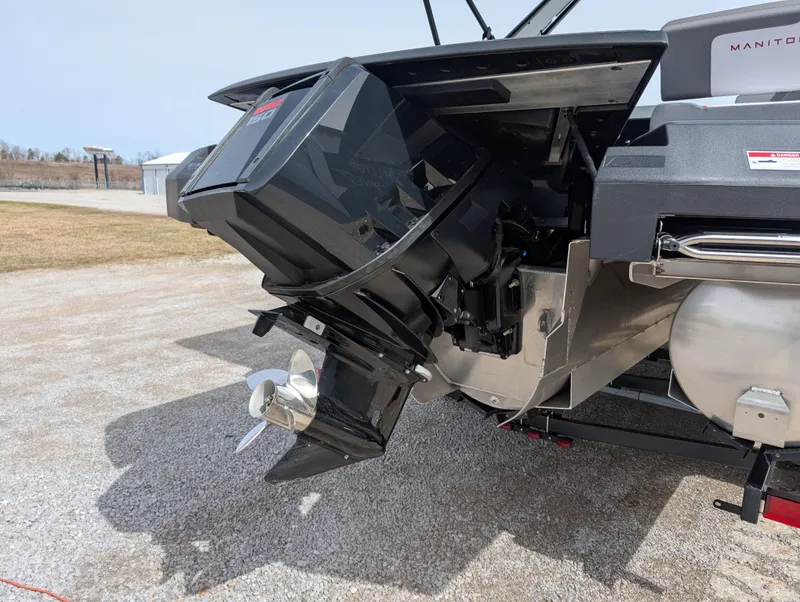 Slide: The Image of 2025 Manitou Cruise boat engine and propeller on a trailer, outdoor setting. - 37