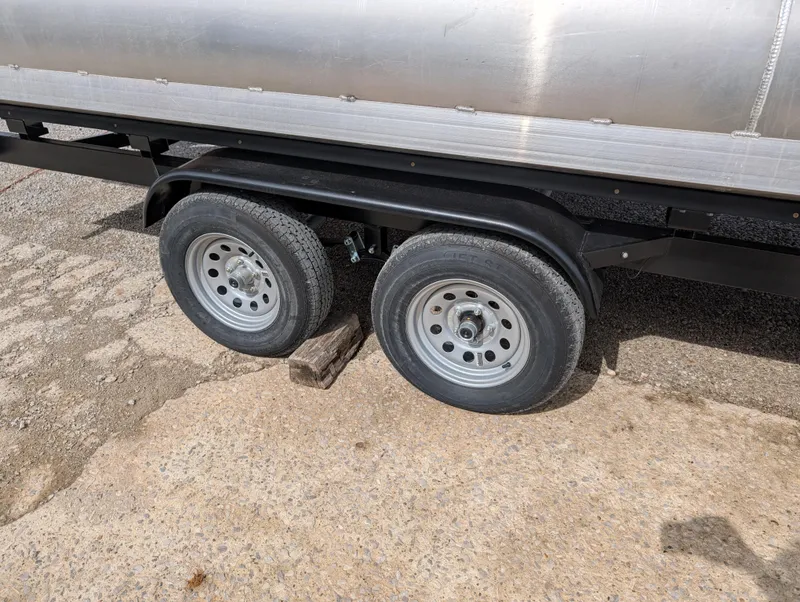 Slide: The Image of Trailer wheels of a 2025 Manitou Cruise boat on a concrete surface. - 39
