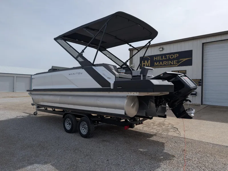 Slide: The Image of 2025 Manitou Cruise pontoon boat on trailer at Hilltop Marine dealership. - 4