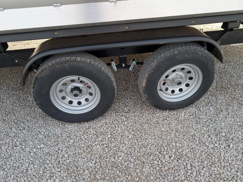 Slide: The Image of 2025 Manitou Cruise trailer wheels on gravel surface. - 42