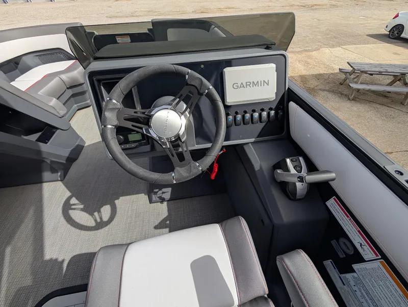 Slide: The Image of 2025 Manitou Cruise boat dashboard with Garmin navigation system and modern steering wheel. - 48