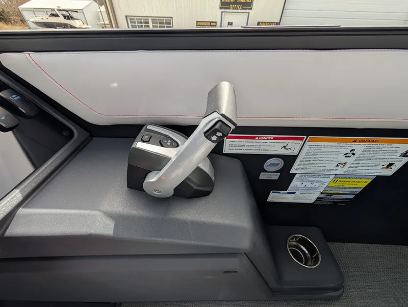 Slide: The Image of Control panel of 2025 Manitou Cruise boat with throttle lever and safety instructions. - 49