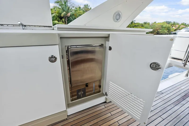 Slide: The Image of 2017 Azimut 72 Flybridge yacht with open cabinet on deck, revealing stainless steel appliance. - 25