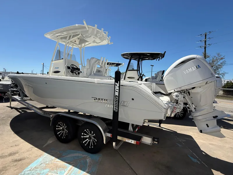 Slide: The Image of 2025 Pathfinder 2400 Open boat on trailer with Yamaha engine, parked outdoors. - 1