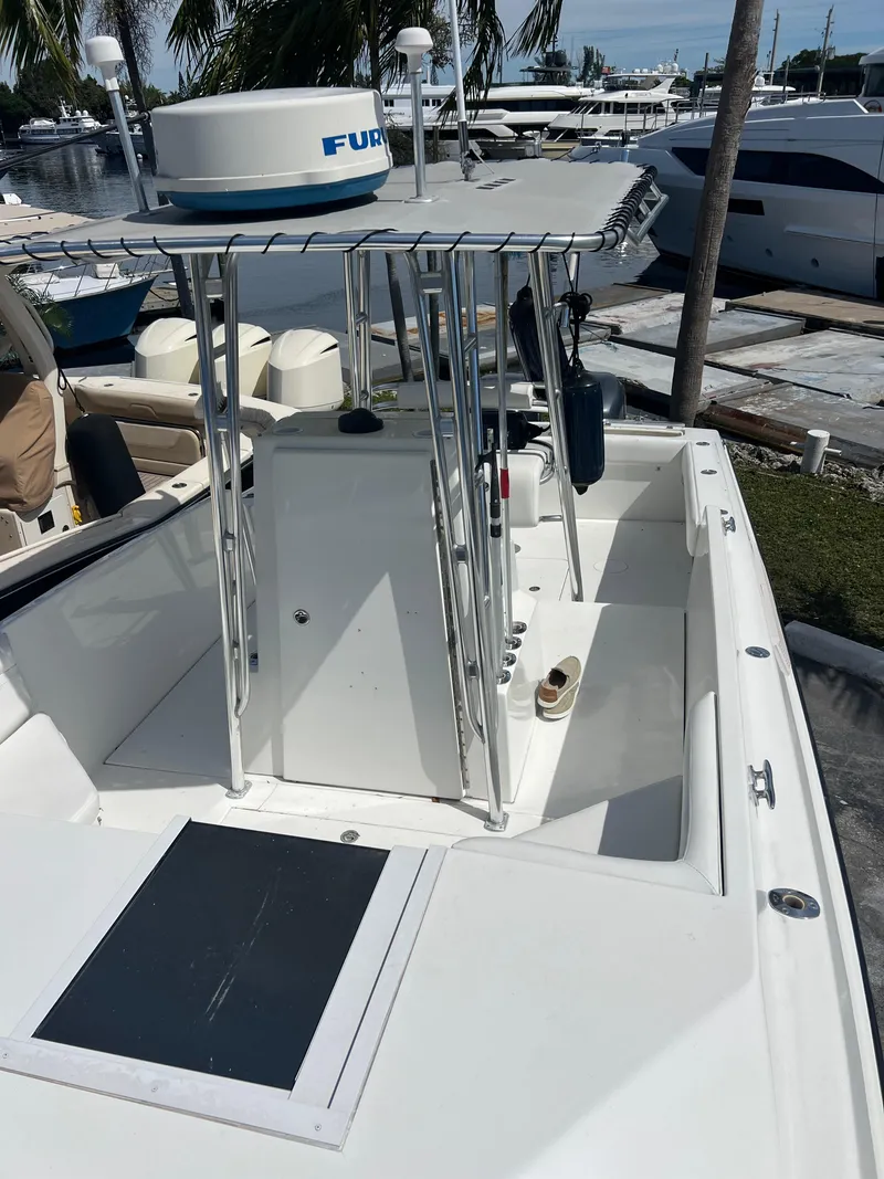 Slide: The Image of 1999 Contender 35 Center Console with Forward Cuddy, docked, featuring spacious deck and sleek design. - 12