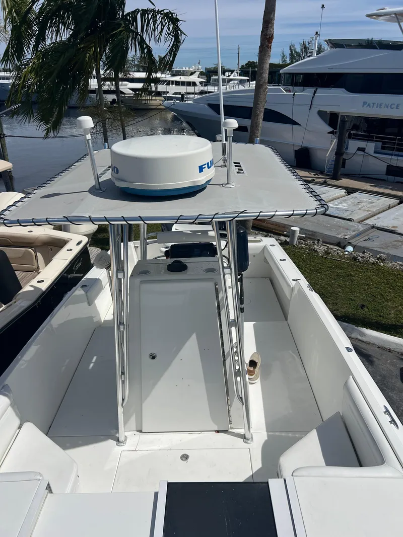 Slide: The Image of 1999 Contender 35 Center Console boat with forward cuddy, docked near luxury yachts. - 13