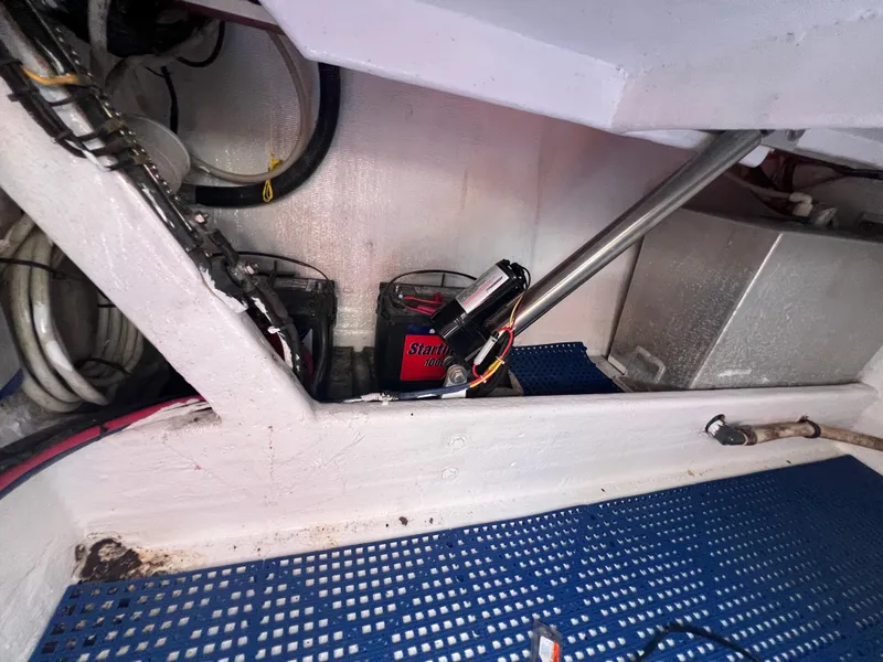 Slide: The Image of 1999 Contender 35 Center Console engine compartment with battery and hydraulic components. - 15