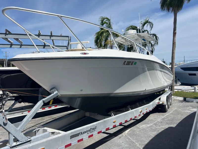 Slide: The Image of 1999 Contender 35 Center Console boat on trailer, parked outdoors under clear sky. - 2