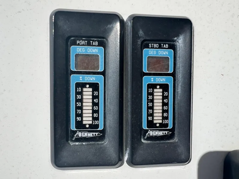 Slide: The Image of Trim tab controls on a 1999 Contender 35 Center Console boat. - 24