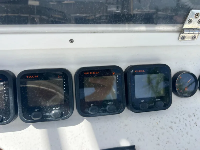 Slide: The Image of Dashboard of a 1999 Contender 35 Center Console boat with tachometer, speed, and fuel gauges. - 25