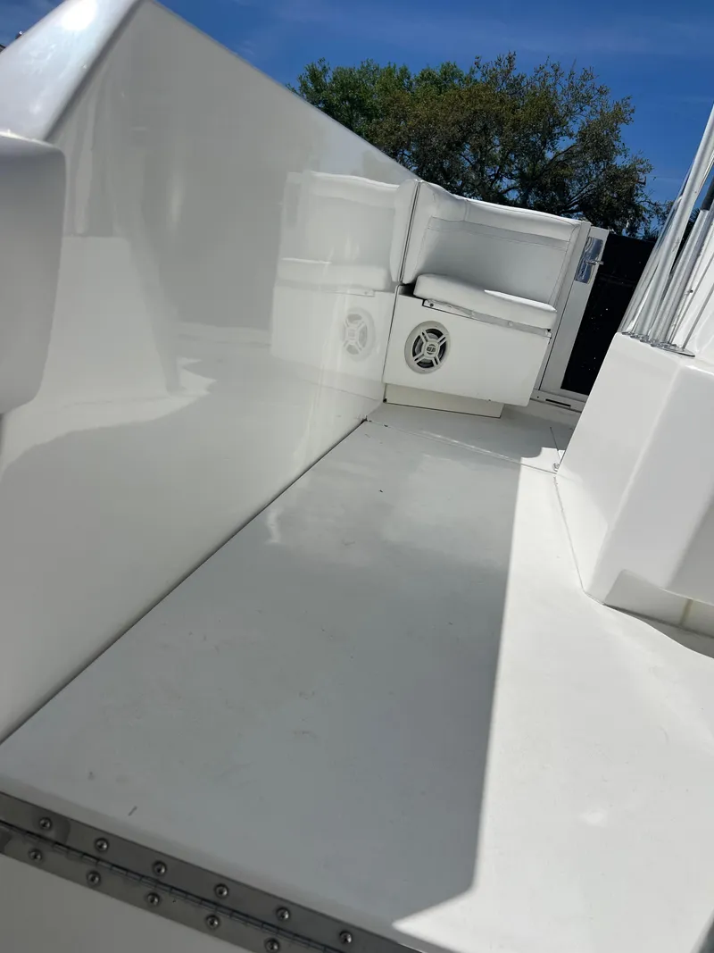 Slide: The Image of 1999 Contender 35 Center Console boat interior, featuring a forward cuddy and sleek white design. - 28