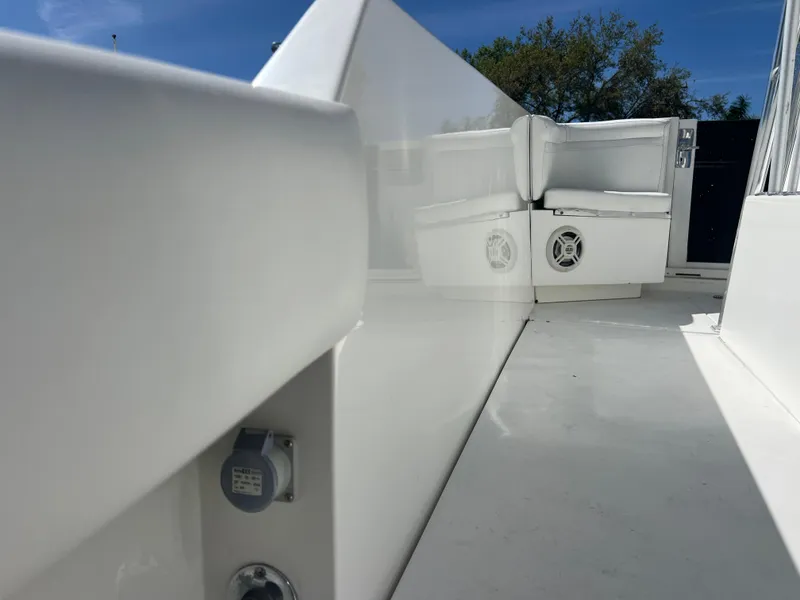 Slide: The Image of 1999 Contender 35 Center Console boat interior with forward cuddy, white seating, and clear sky. - 29