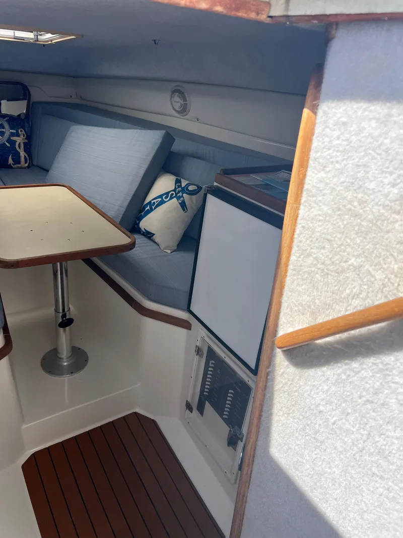 Slide: The Image of 1999 Contender 35 Center Console with forward cuddy, featuring cozy interior seating and table. - 34