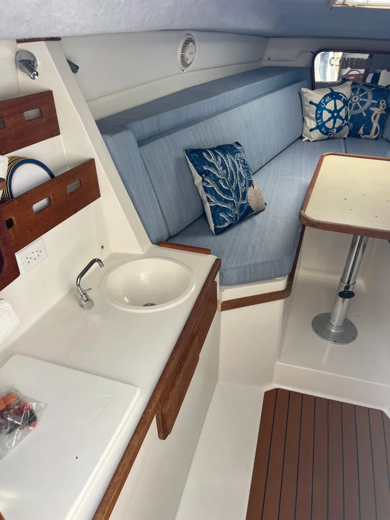 Slide: The Image of 1999 Contender 35 Center Console interior with sink, seating, and table. - 35
