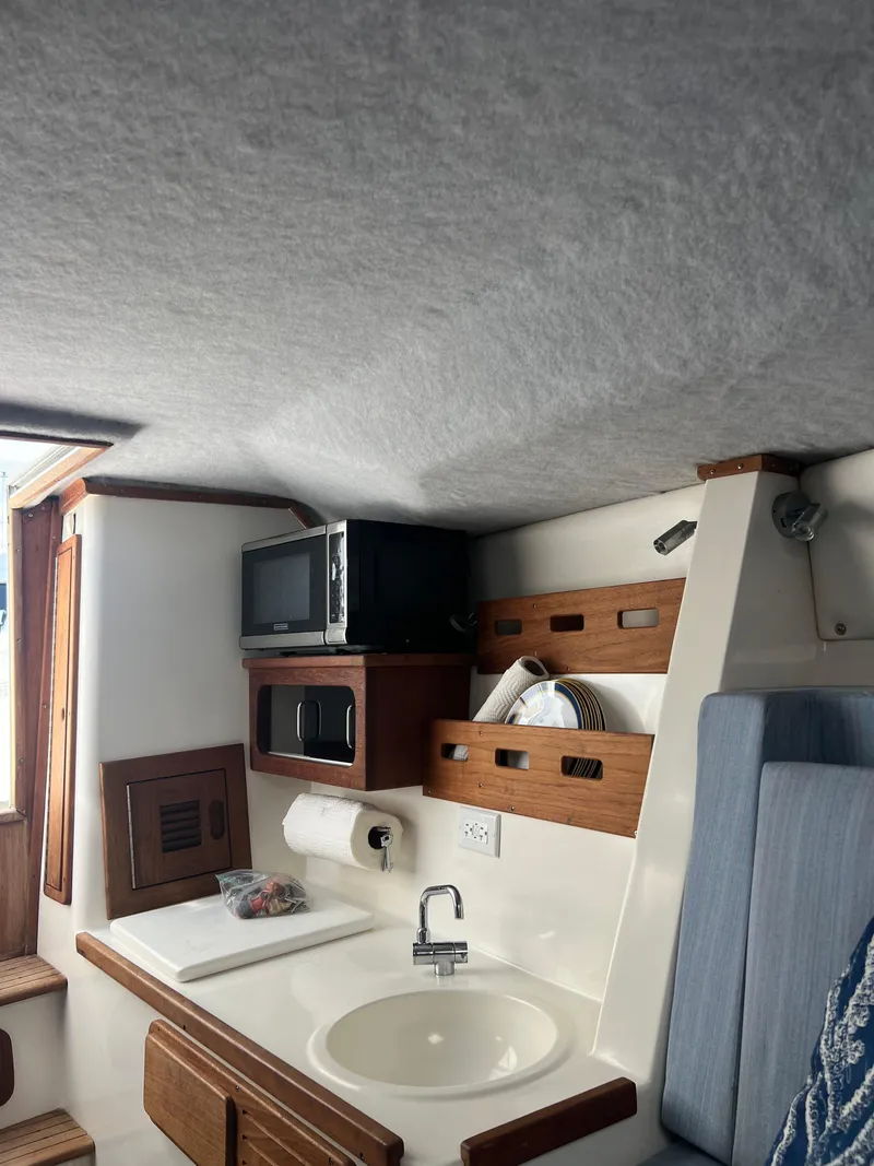 Slide: The Image of 1999 Contender 35 Center Console interior with sink, microwave, and storage. - 39