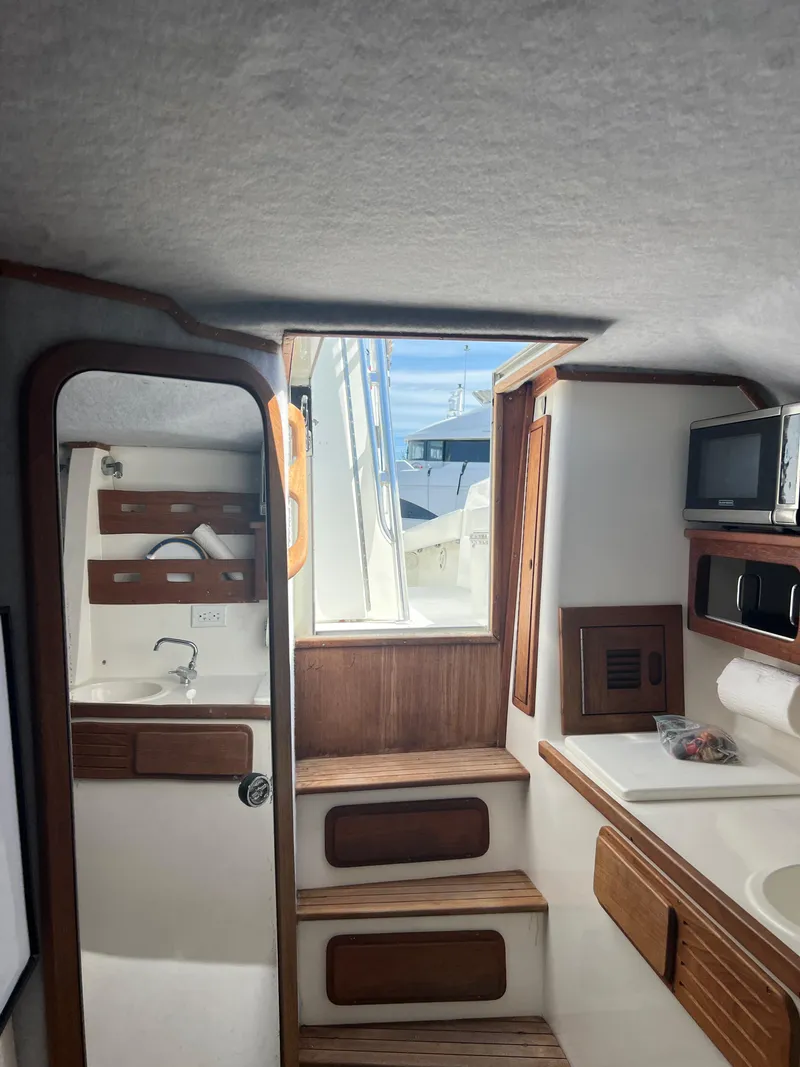 Slide: The Image of Interior of 1999 Contender 35 Center Console with forward cuddy, featuring wood accents and compact design. - 40