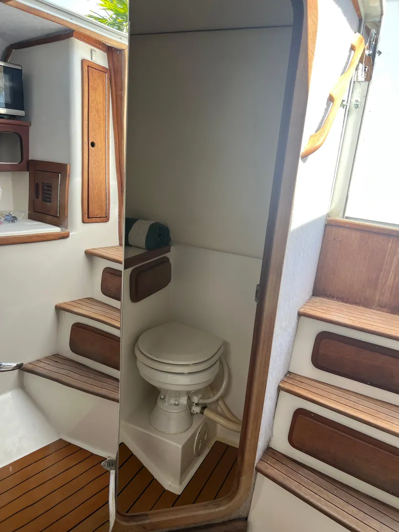 Slide: The Image of 1999 Contender 35 Center Console boat interior with compact marine toilet. - 41