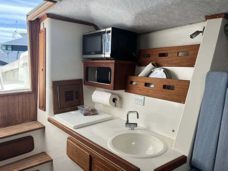 Slide: The Image of Interior of 1999 Contender 35 Center Console with forward cuddy, featuring kitchenette and storage. - 43