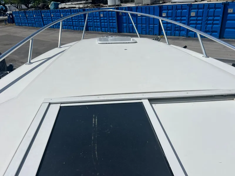 Slide: The Image of 1999 Contender 35 Center Console boat with forward cuddy, docked near blue containers. - 45