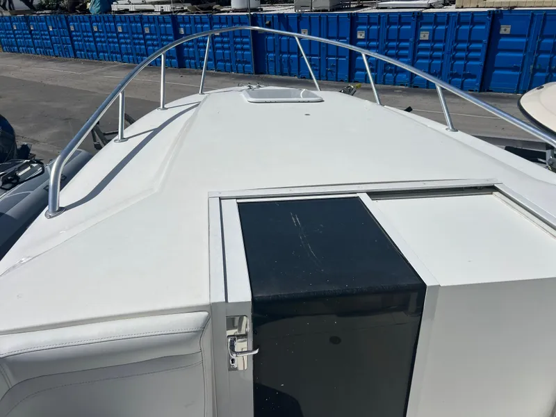 Slide: The Image of 1999 Contender 35 Center Console with forward cuddy, white deck, docked near blue containers. - 47