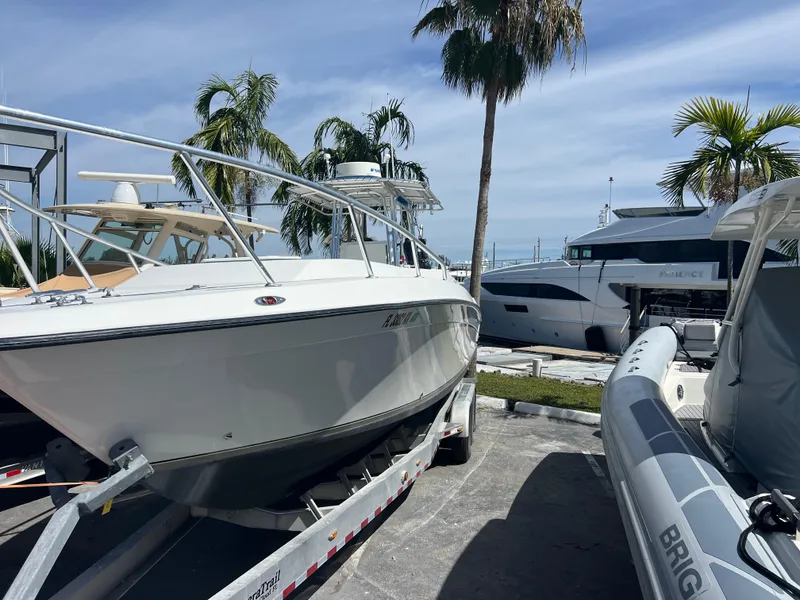 Slide: The Image of 1999 Contender 35 Center Console boat on trailer, surrounded by palm trees and other boats. - 6