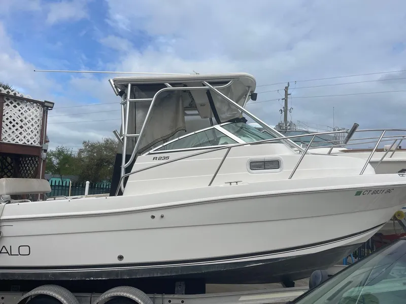 Slide: The Image of 2005 Robalo R235 Walkaround boat on trailer, side view under cloudy sky. - 1