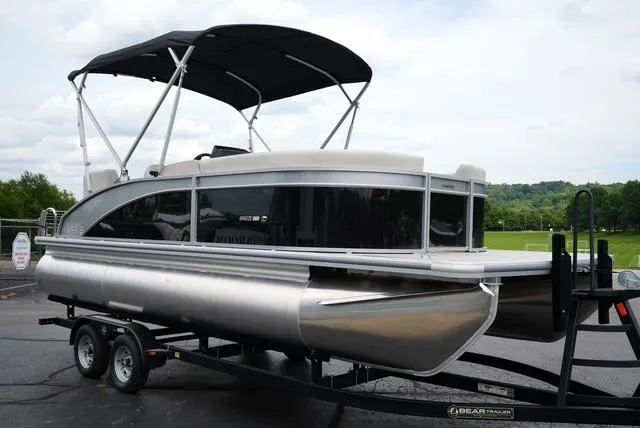 Slide: The Image of 2025 Harris Breeze 210 pontoon boat on trailer, parked outdoors. - 3