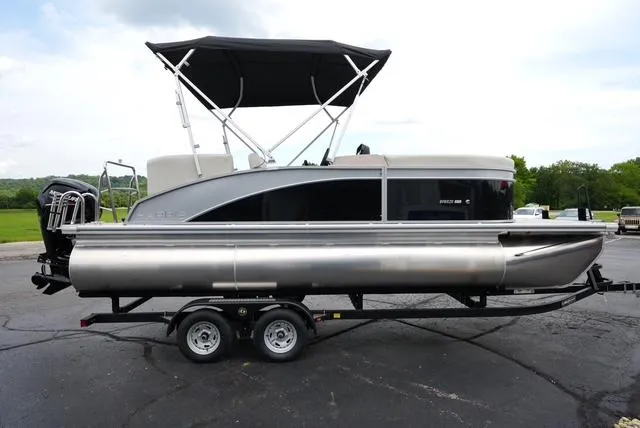 Slide: The Image of 2025 Harris Breeze 210 pontoon boat on trailer, featuring sleek design and canopy. - 4