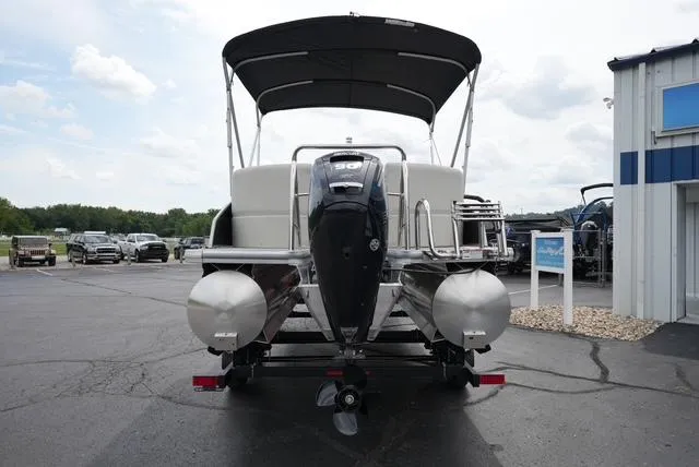 Slide: The Image of 2025 Harris Breeze 210 pontoon boat with canopy, parked on a trailer. - 6