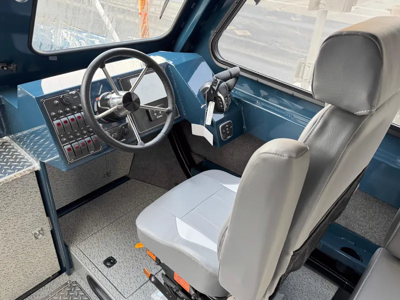 Slide: The Image of Interior of 2025 Hewescraft 270 Alaskan ET HT boat, featuring steering wheel and control panel. - 5