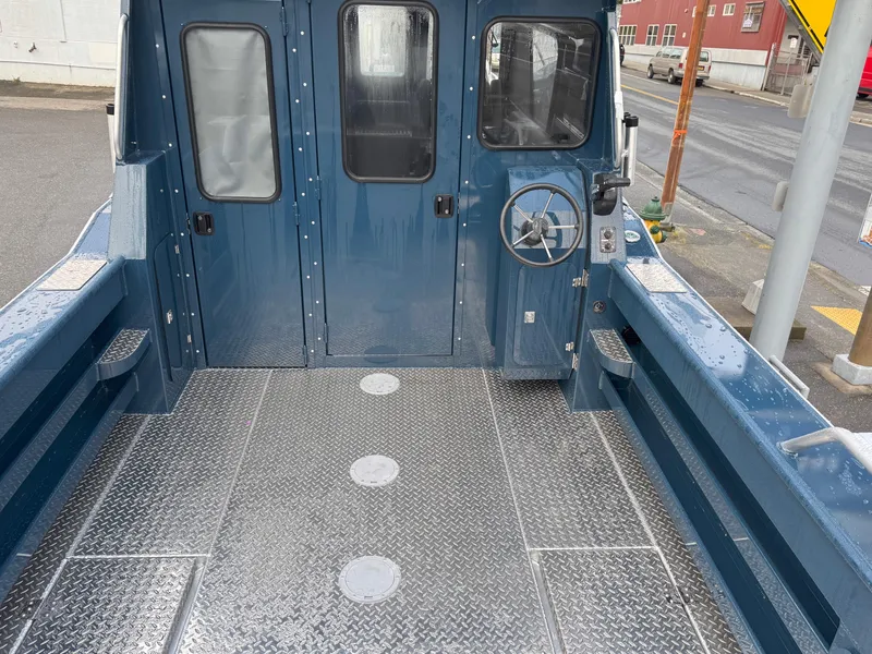 Slide: The Image of 2025 Hewescraft 270 Alaskan ET HT boat deck with steering wheel and metal flooring. - 7