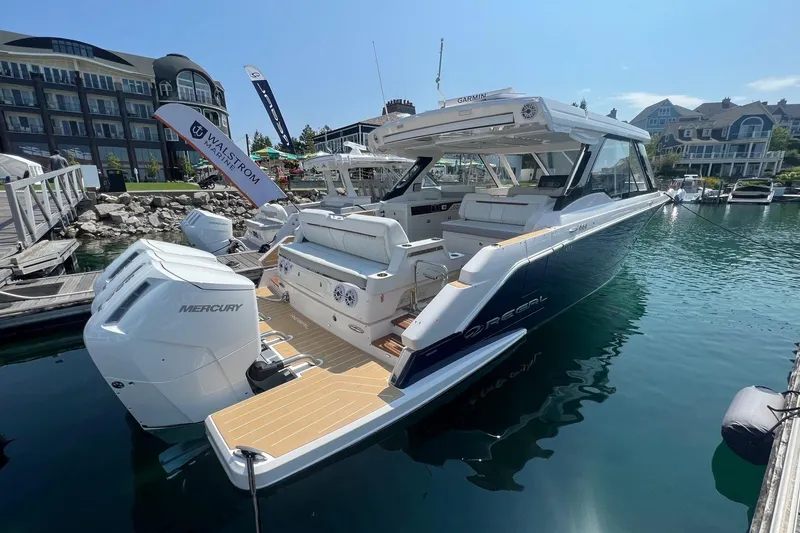 The Image of 2026 Regal LX43 luxury boat docked at marina with Mercury engines. - 1