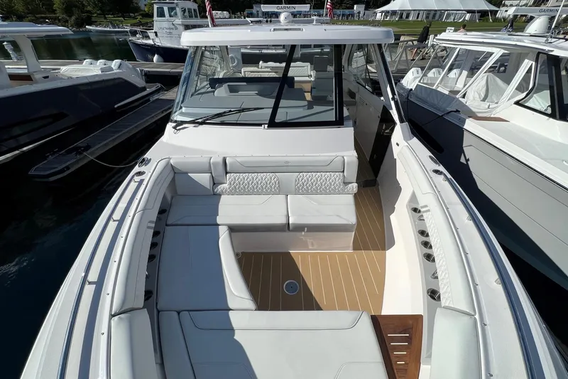 Slide: The Image of 2026 Regal LX43 boat with spacious seating and modern design, docked at a marina. - 19