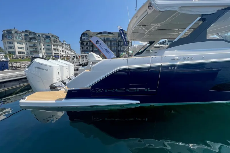 Slide: The Image of 2026 Regal LX43 yacht docked, featuring sleek design and Mercury outboard engines. - 3