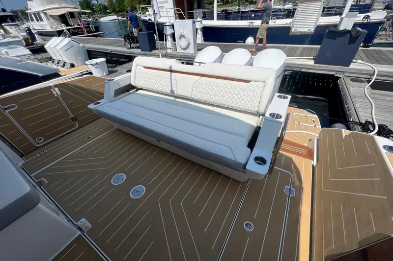 Slide: The Image of 2026 Regal LX43 boat with luxurious seating and modern deck design at a marina. - 7