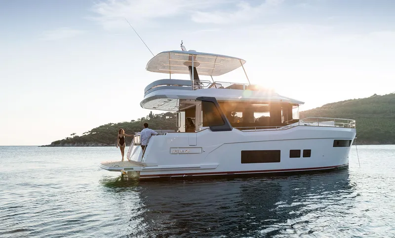 Slide: The Image of Modern Sirena 48 yacht on serene water, 2025 model, with people enjoying the sunset. - 0