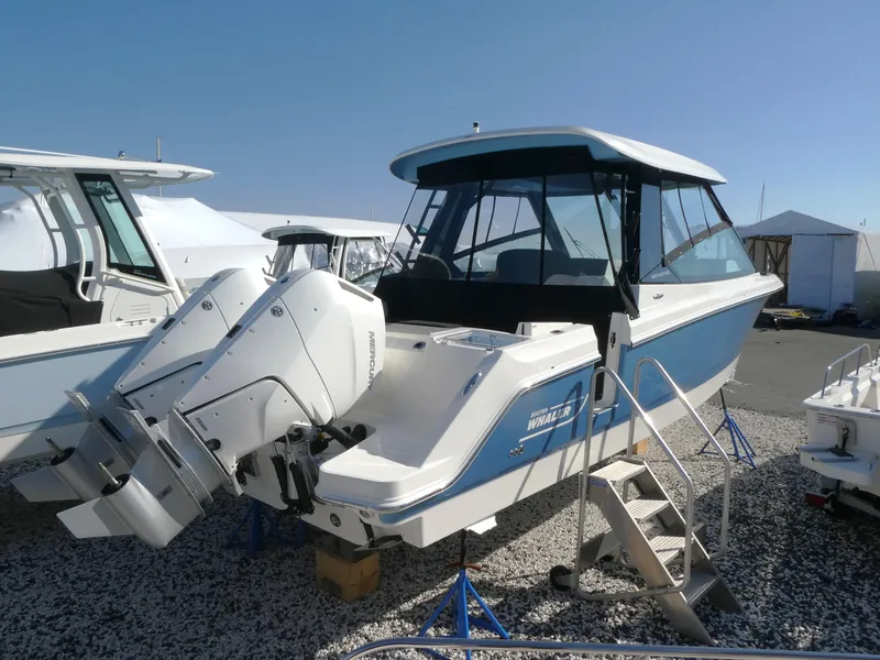 Slide: The Image of 2025 Boston Whaler 330 Vantage boat with dual engines, displayed outdoors. - 2