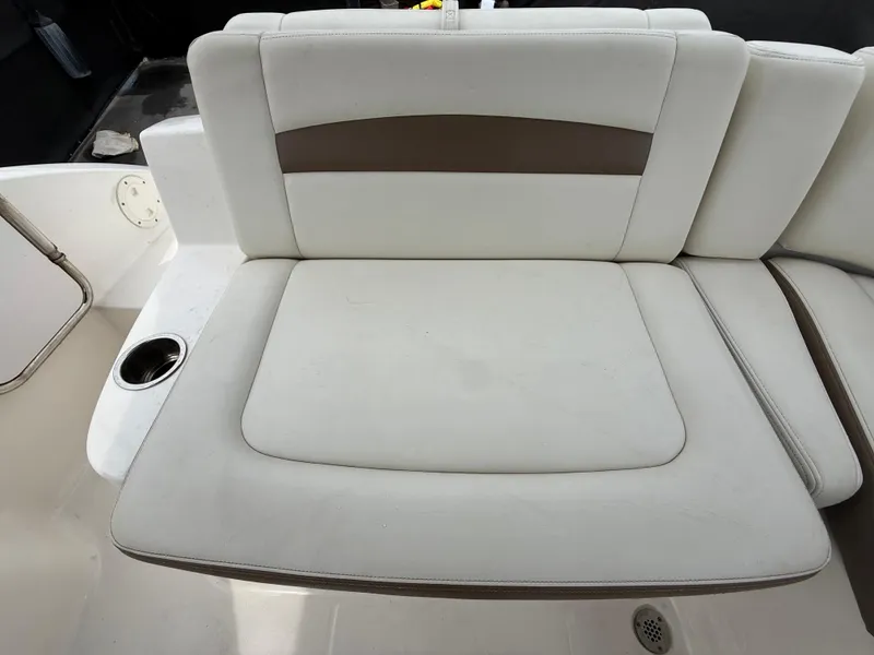 Slide: The Image of 2015 Chaparral Sunesta 224 boat interior with white cushioned seating and cup holder. - 22