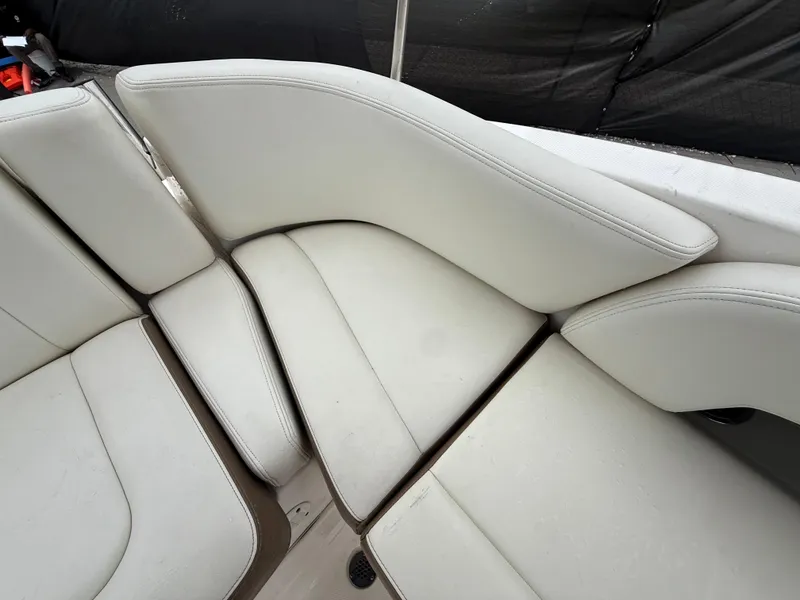 Slide: The Image of 2015 Chaparral Sunesta 224 boat interior with white cushioned seating. - 24