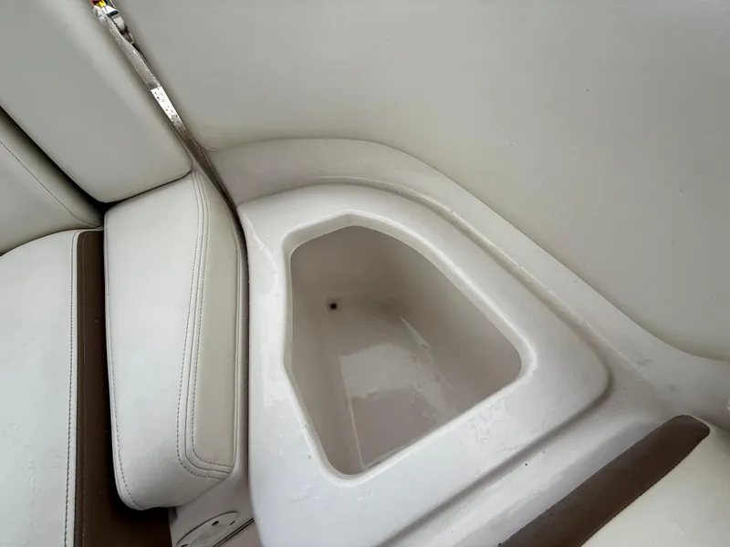 Slide: The Image of 2015 Chaparral Sunesta 224 boat interior with white seating and storage compartment. - 25