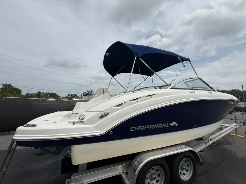 Slide: The Image of 2015 Chaparral Sunesta 224 boat on trailer with blue canopy under cloudy sky. - 3