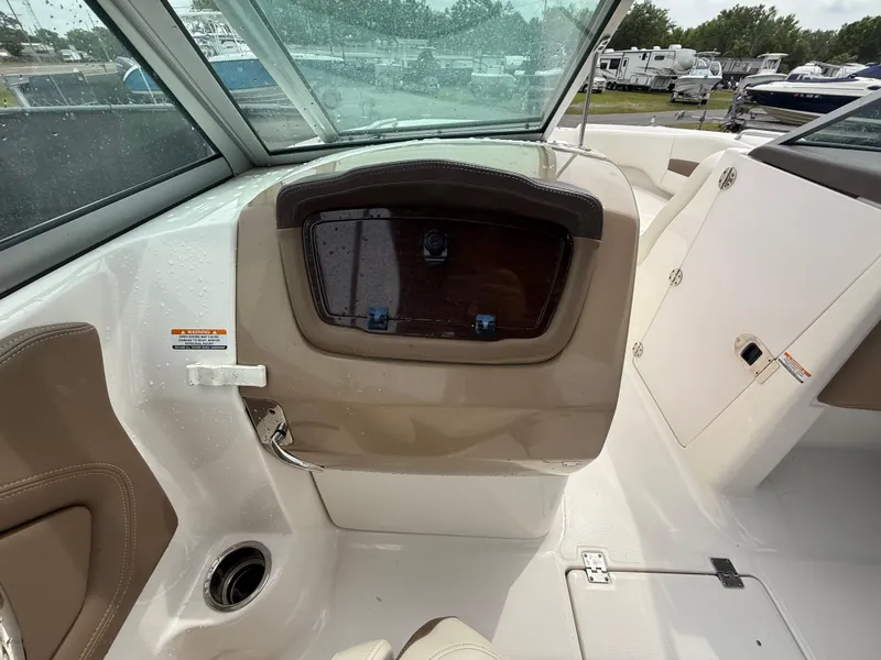 Slide: The Image of 2015 Chaparral Sunesta 224 boat interior with beige seating and dashboard. - 42