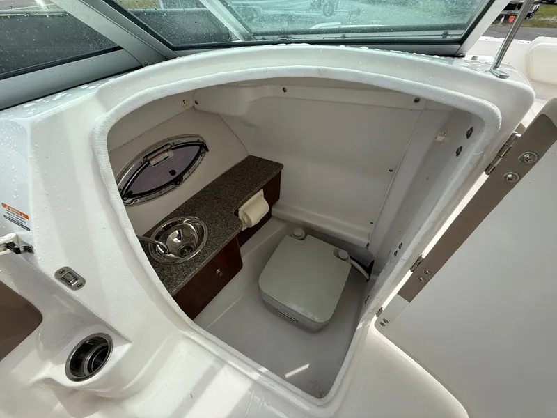 Slide: The Image of 2015 Chaparral Sunesta 224 boat interior with compact restroom and sink. - 44