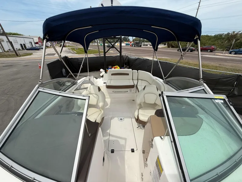 Slide: The Image of 2015 Chaparral Sunesta 224 boat with blue canopy and spacious seating. - 46