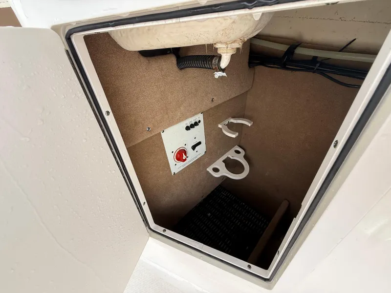 Slide: The Image of 2015 Chaparral Sunesta 224 storage compartment with control panel and hooks. - 49