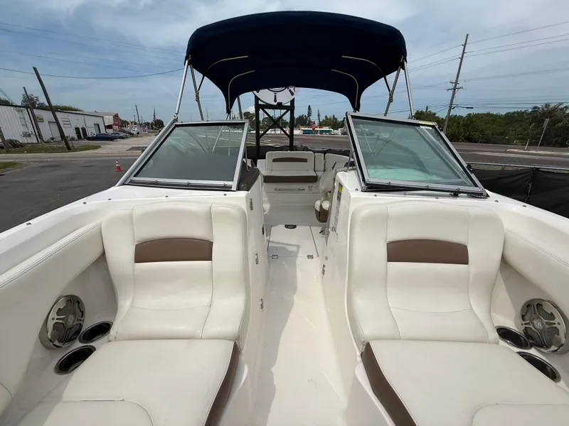 Slide: The Image of 2015 Chaparral Sunesta 224 boat interior with white seating and blue canopy. - 51