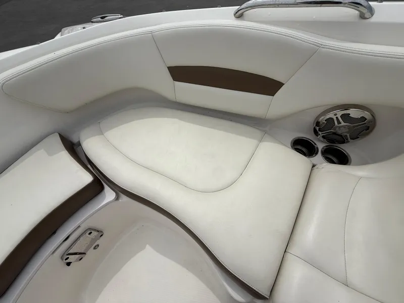 Slide: The Image of 2015 Chaparral Sunesta 224 boat interior with white and brown seating, cup holders, and speaker. - 52