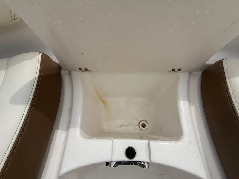 Slide: The Image of 2015 Chaparral Sunesta 224 boat storage compartment with white and brown seating. - 57