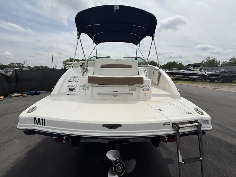 Slide: The Image of 2015 Chaparral Sunesta 224 boat with canopy, rear view, parked on pavement. - 6